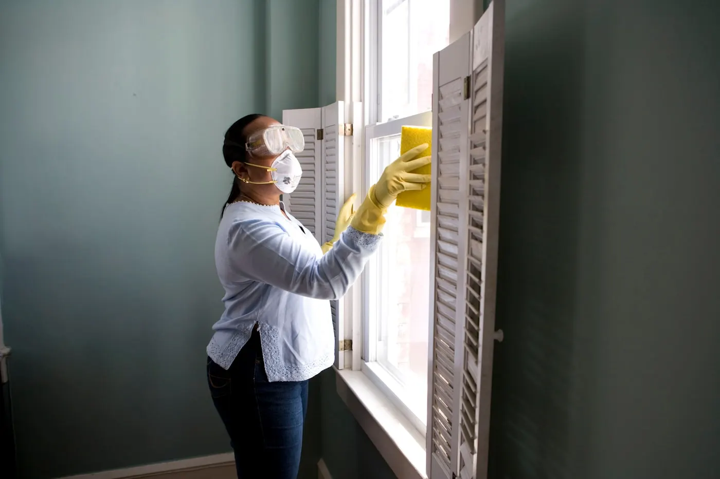 Professional cleaner wiping a bright commercial window